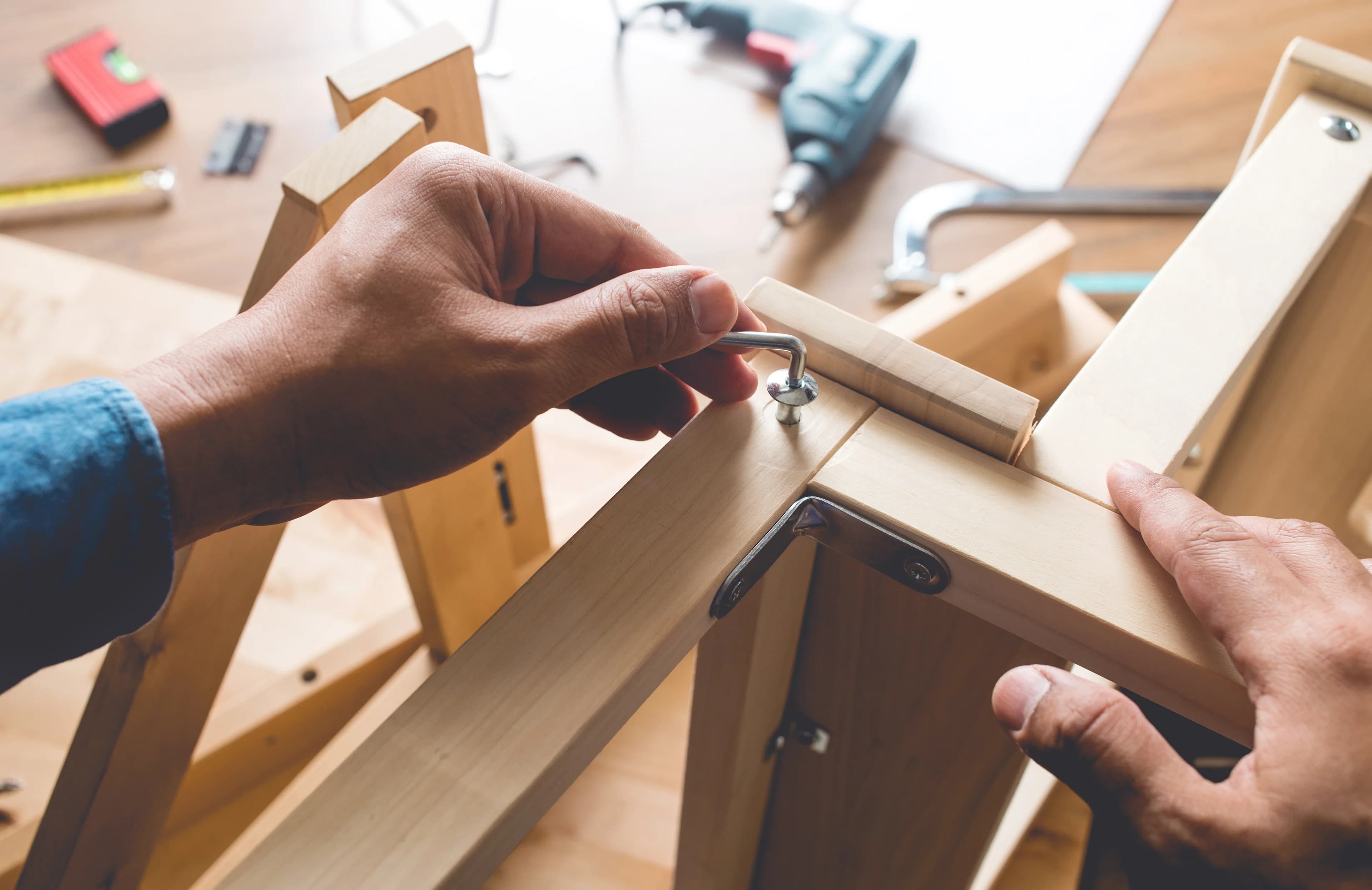 A person assembling a wooden piece of furniture.